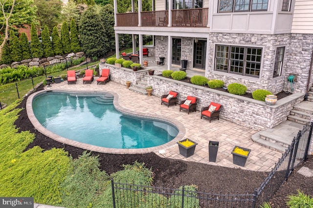 view of swimming pool with a patio, fence, and a fenced in pool