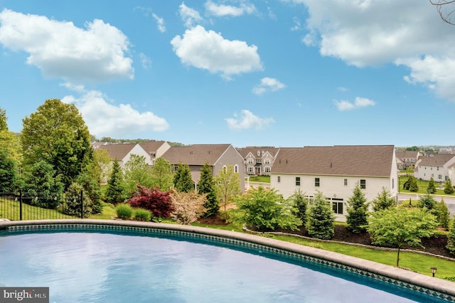 pool with a residential view and fence