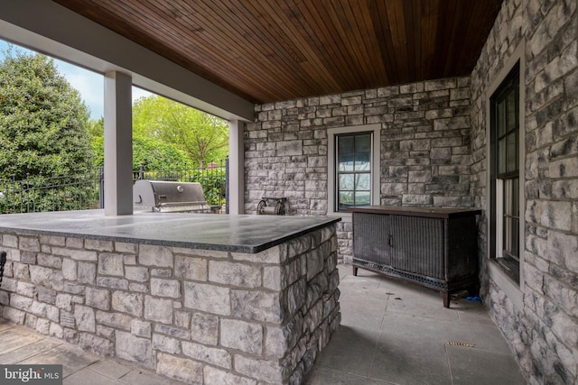 view of patio / terrace featuring area for grilling, a bar, and an outdoor kitchen