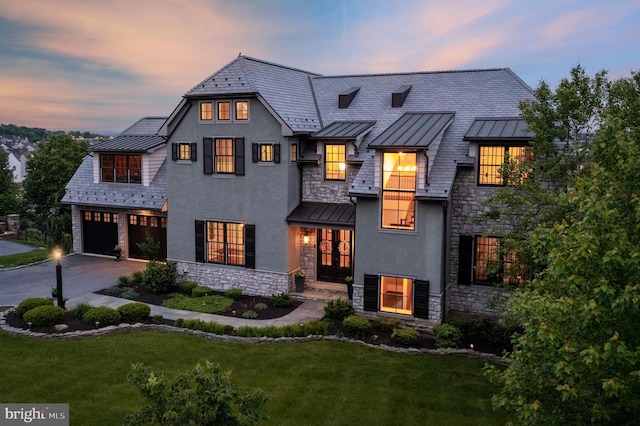 view of front of house with a standing seam roof, metal roof, and driveway