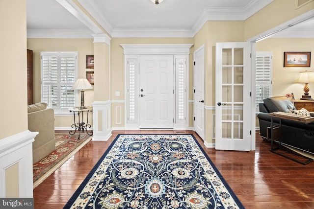 entryway with ornamental molding, visible vents, ornate columns, and hardwood / wood-style flooring