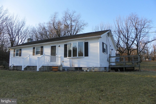 view of front facade featuring a chimney, a deck, and a front lawn