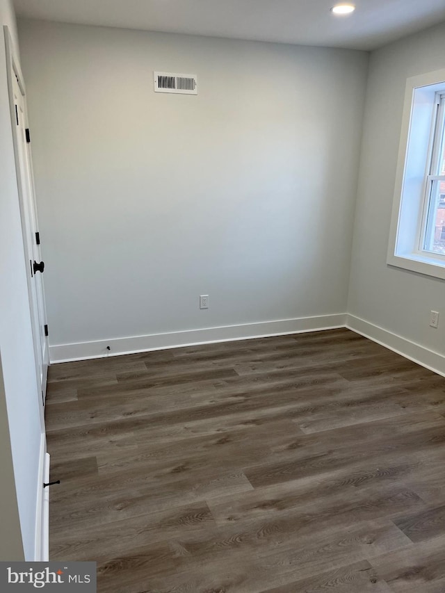 spare room featuring recessed lighting, visible vents, dark wood finished floors, and baseboards