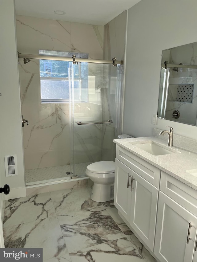 full bathroom featuring marble finish floor, a marble finish shower, double vanity, visible vents, and a sink