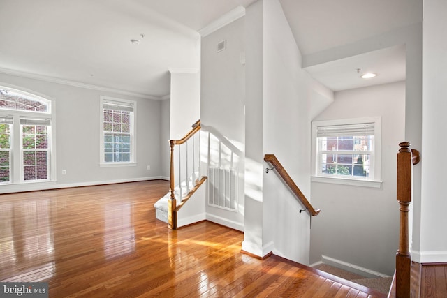 stairs with wood-type flooring, visible vents, baseboards, and a healthy amount of sunlight