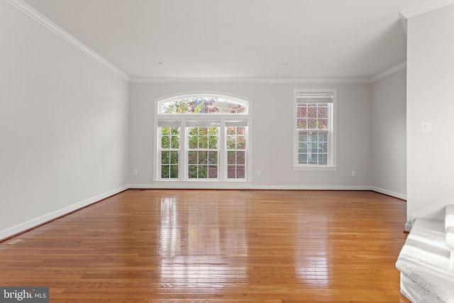 unfurnished living room featuring ornamental molding, light wood-type flooring, and baseboards