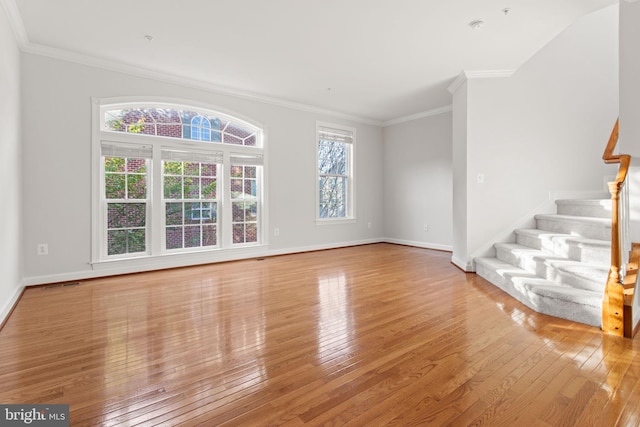 unfurnished living room featuring crown molding, stairway, baseboards, and light wood-style floors