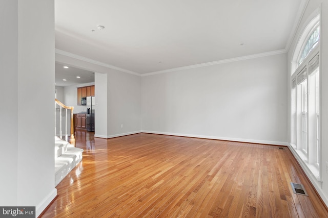 unfurnished living room featuring baseboards, visible vents, and light wood-style floors