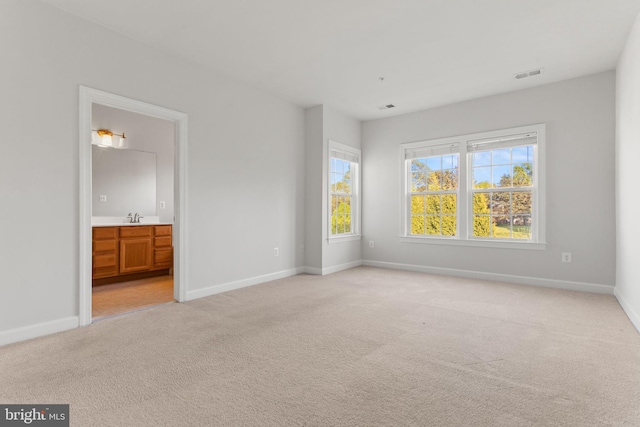 unfurnished bedroom featuring baseboards, visible vents, and light colored carpet