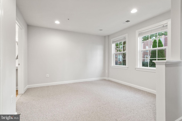 unfurnished room with carpet, visible vents, baseboards, and recessed lighting