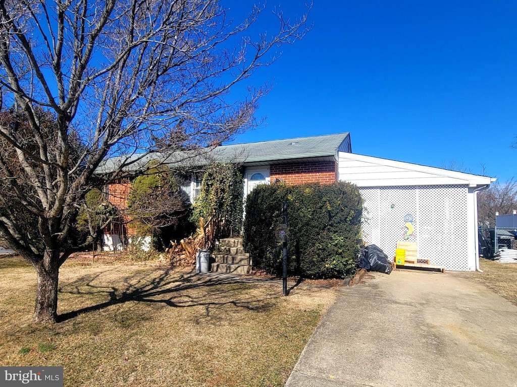 view of front of home featuring brick siding and driveway