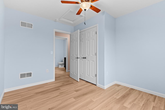 unfurnished bedroom featuring baseboards, a closet, visible vents, and light wood-style floors