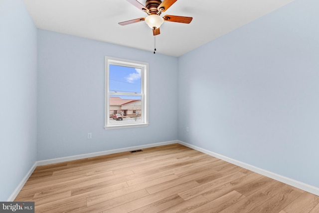 spare room with light wood-style floors, visible vents, and baseboards