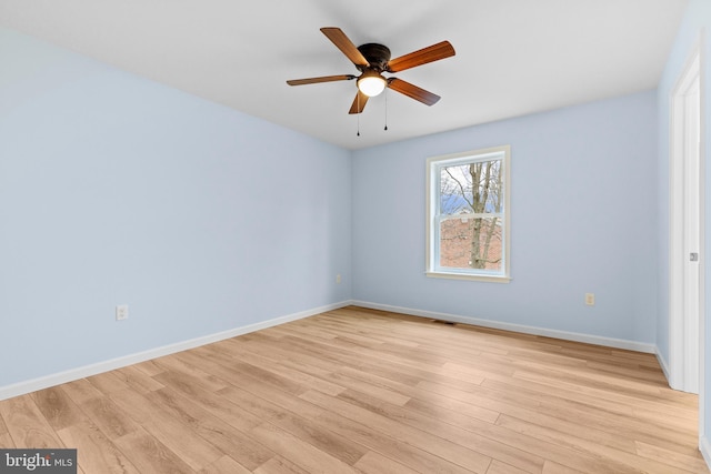 empty room featuring light wood-style flooring, visible vents, baseboards, and ceiling fan