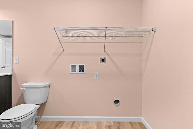 interior space featuring light wood-style flooring, hookup for an electric dryer, laundry area, washer hookup, and baseboards