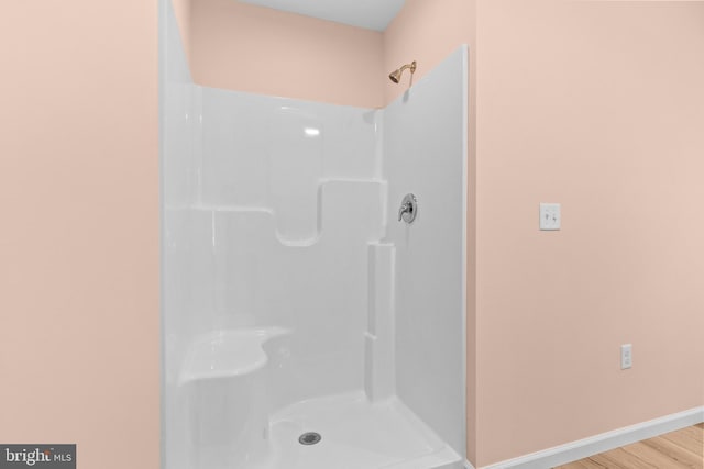 full bath with wood finished floors, walk in shower, and baseboards