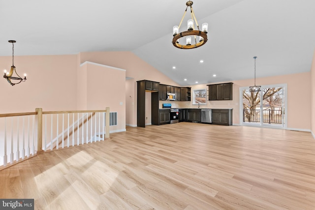 unfurnished living room with high vaulted ceiling, light wood-style flooring, visible vents, baseboards, and an inviting chandelier