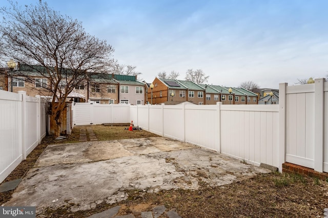 view of yard featuring a residential view, a patio area, and a fenced backyard