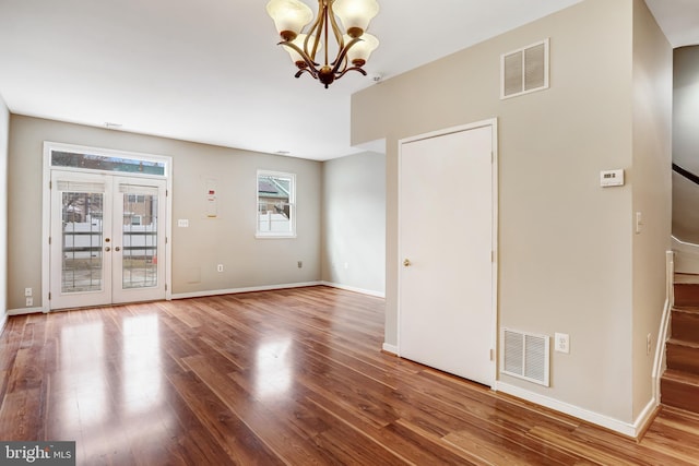 spare room with baseboards, visible vents, wood finished floors, and french doors