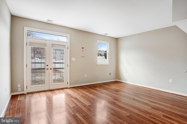 interior space featuring french doors, visible vents, baseboards, and wood finished floors