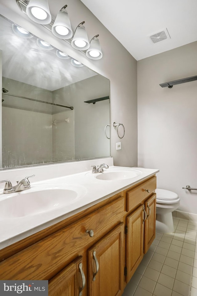 full bathroom featuring double vanity, visible vents, toilet, tile patterned flooring, and a sink