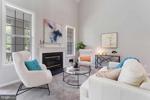 7014 Ellingham Cir Unit F, Alexandria, VA 22315 - living room featuring baseboards, a glass covered fireplace, carpet, and a towering ceiling