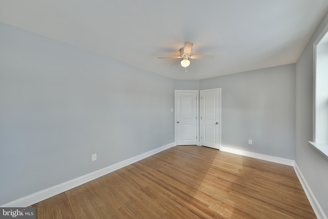 empty room featuring light wood-style floors, ceiling fan, and baseboards