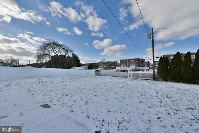 snowy yard featuring fence