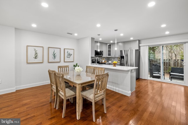 dining space with hardwood / wood-style flooring, recessed lighting, baseboards, and visible vents