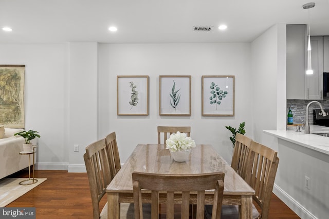 dining space with dark wood-type flooring, recessed lighting, and baseboards