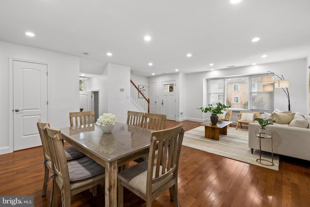 dining room featuring recessed lighting, wood-type flooring, and stairs