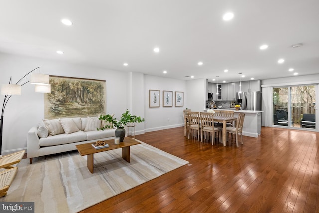 living room with recessed lighting, light wood-type flooring, and baseboards