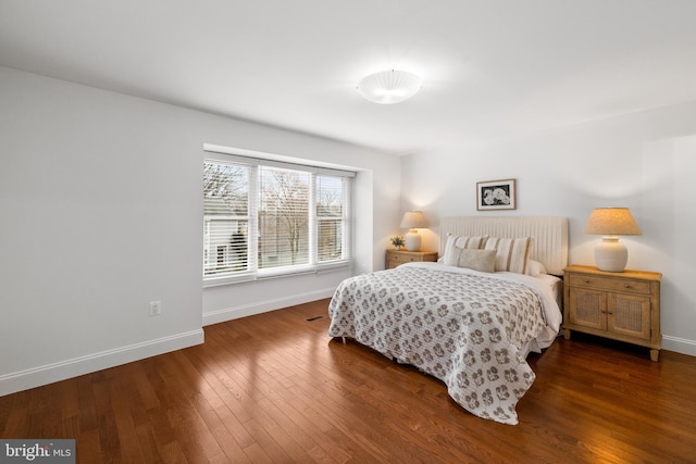 bedroom with baseboards and hardwood / wood-style flooring