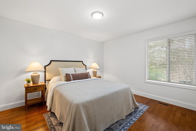 bedroom featuring visible vents, baseboards, and hardwood / wood-style flooring