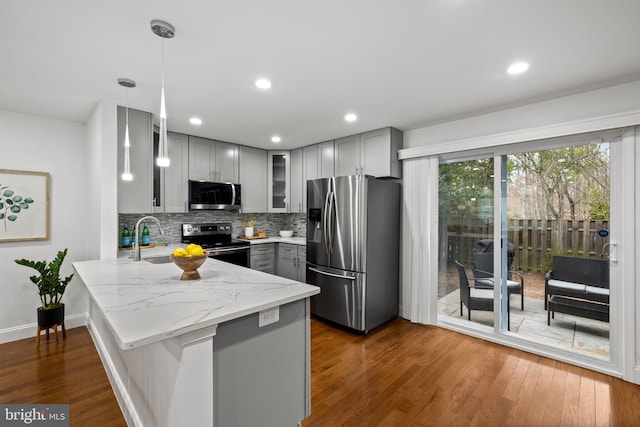 kitchen featuring dark wood-style floors, appliances with stainless steel finishes, a peninsula, and gray cabinetry