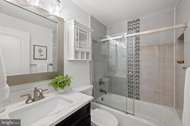 full bath featuring toilet, vanity, and bath / shower combo with glass door