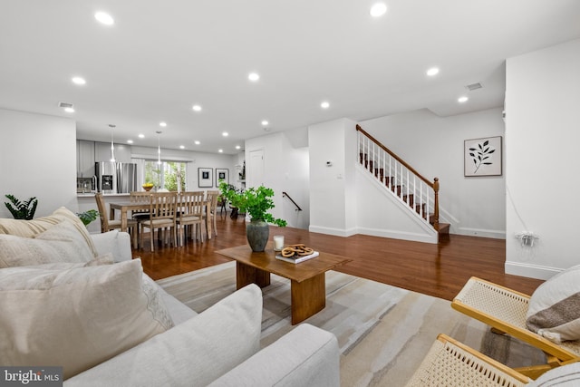 living area with stairway, recessed lighting, baseboards, and light wood-style flooring