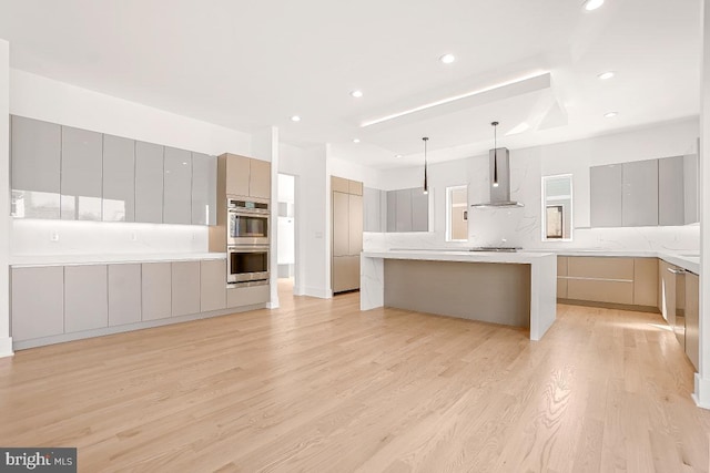 kitchen featuring stainless steel appliances, gray cabinets, light wood-style flooring, modern cabinets, and wall chimney exhaust hood