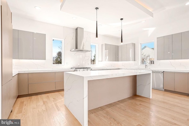 kitchen featuring wall chimney range hood, modern cabinets, gray cabinets, and stainless steel dishwasher