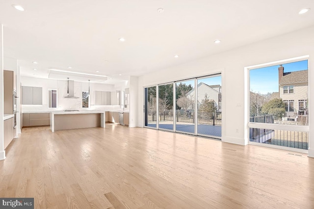 unfurnished living room with light wood-style flooring, a sink, and recessed lighting