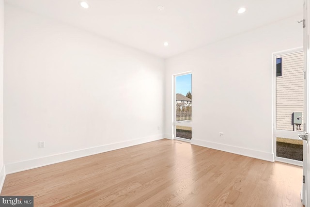 unfurnished room with light wood-type flooring, baseboards, and recessed lighting