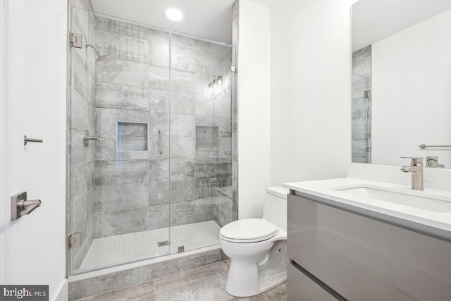 full bathroom featuring a stall shower, vanity, and toilet