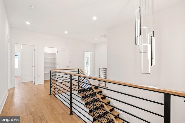 hallway with recessed lighting, plenty of natural light, light wood-style flooring, and an upstairs landing