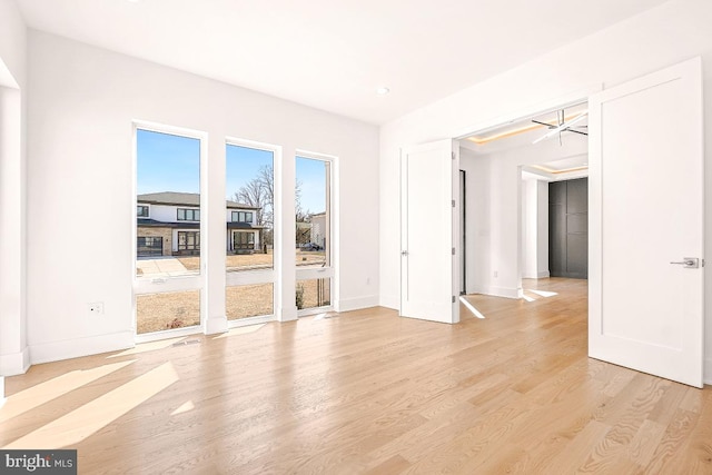 unfurnished room featuring light wood finished floors and baseboards