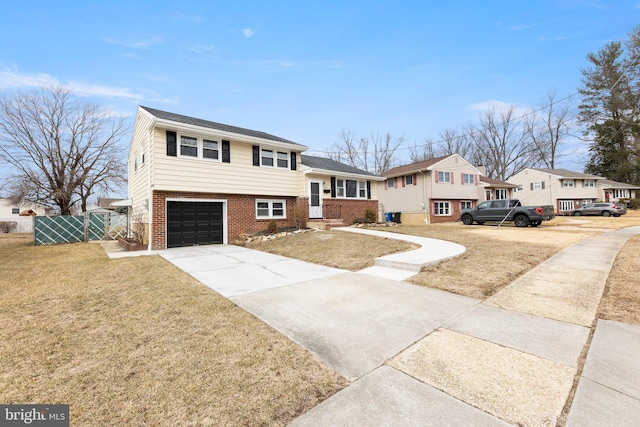 tri-level home featuring driveway, brick siding, a front yard, and a residential view