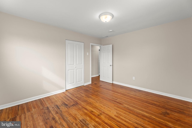 unfurnished bedroom featuring baseboards and wood finished floors