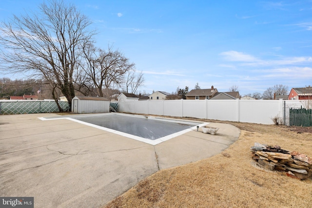 view of swimming pool featuring a storage shed, a fenced backyard, an outdoor structure, and a patio