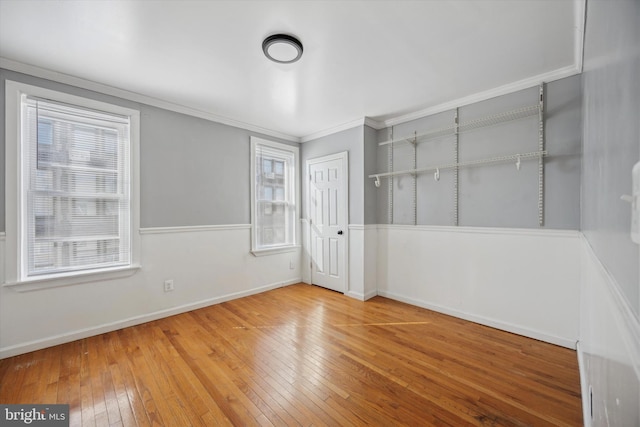 empty room featuring plenty of natural light, wood finished floors, and baseboards