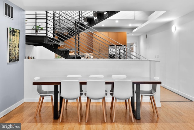 interior space featuring hardwood / wood-style flooring, recessed lighting, visible vents, baseboards, and stairs