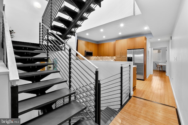 stairs featuring baseboards, wood-type flooring, and recessed lighting